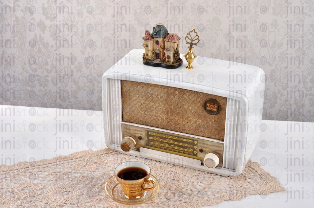 a vintage radio and a cup of coffee on a table.
