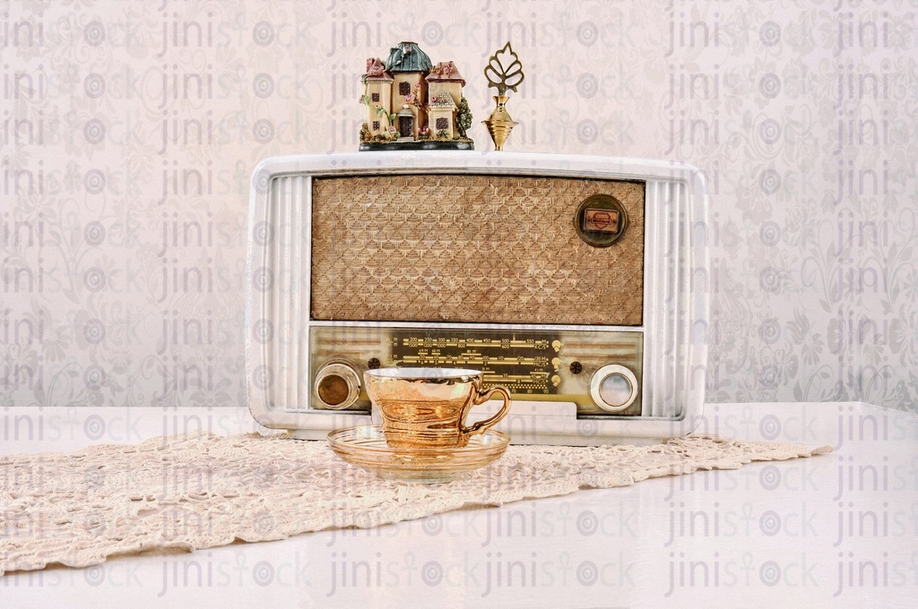 a vintage radio and a cup of coffee on a table.