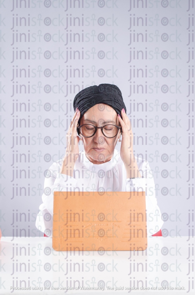 سيدة مصرية عجوز معلمة أو مديرة مدرسة تعاني من الصداع