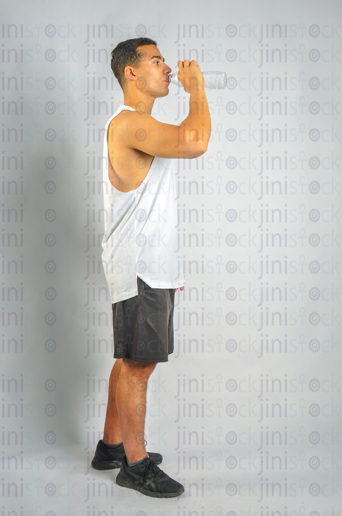 An athletic man drinking water side view