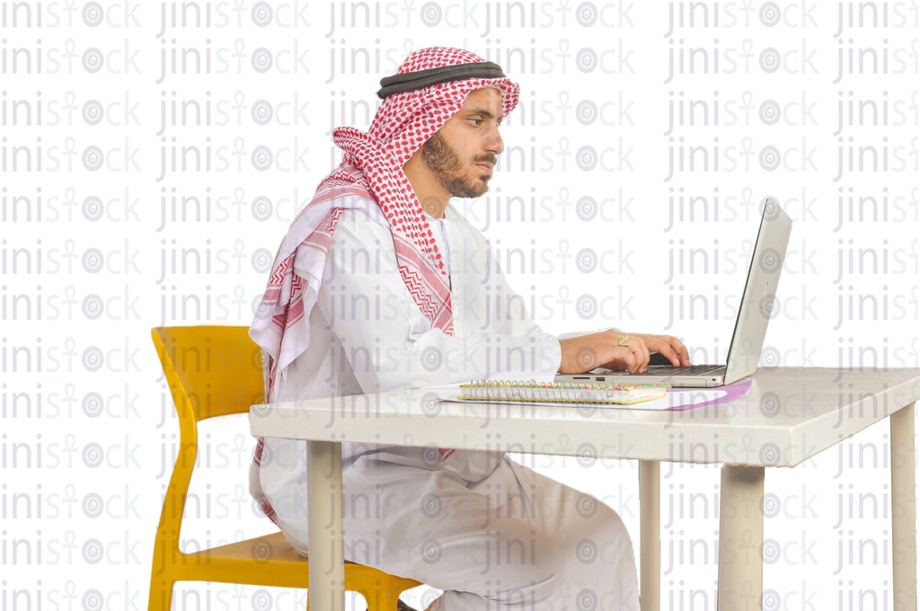 a Saudi, Khaliji, Emirati, or a man from the Gulf working on a laptop in his office