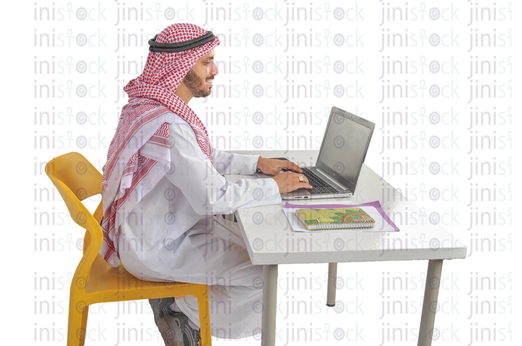 a Saudi, Khaliji, Emirati, or a man from the Gulf working on a laptop in his office