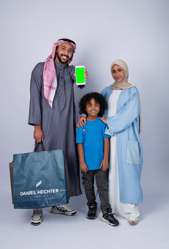 عائلة تقوم بالتسويق وتعرض تطبيق علي الجوال وسعيدة