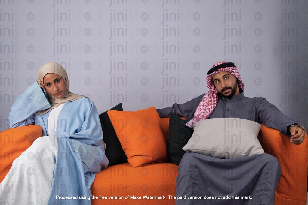 husband and a wife from khaliji saudi arabia from gulf sitting on a couch after a marriage fight