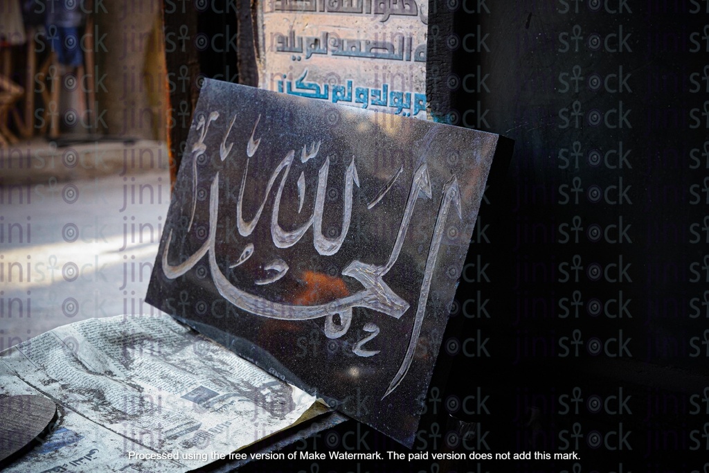 painting al hamdullah on a black board