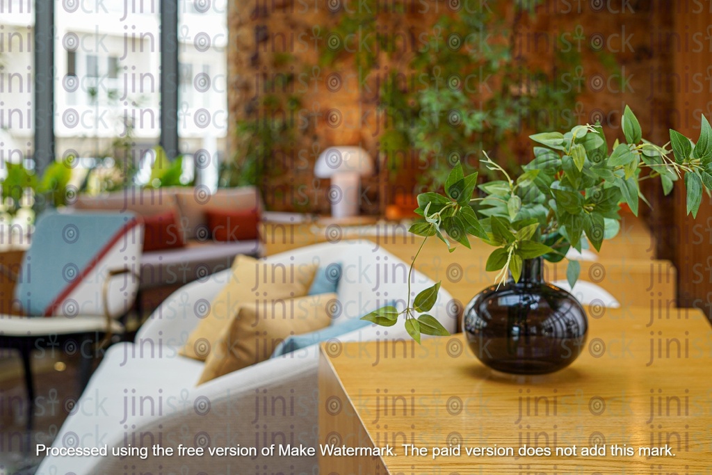 dark glass vase with green leaves inside in a  living room