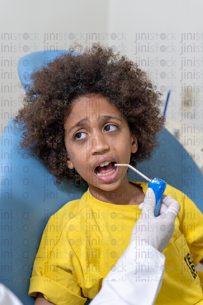 Little Egyptian boy with curly hair scared from the dental