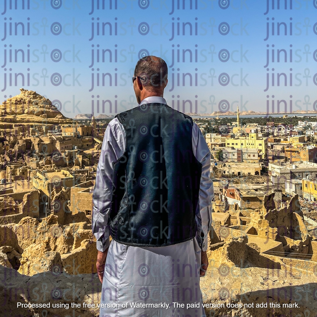 nubian man with his back to the camera and his face to the shali castle in siwa