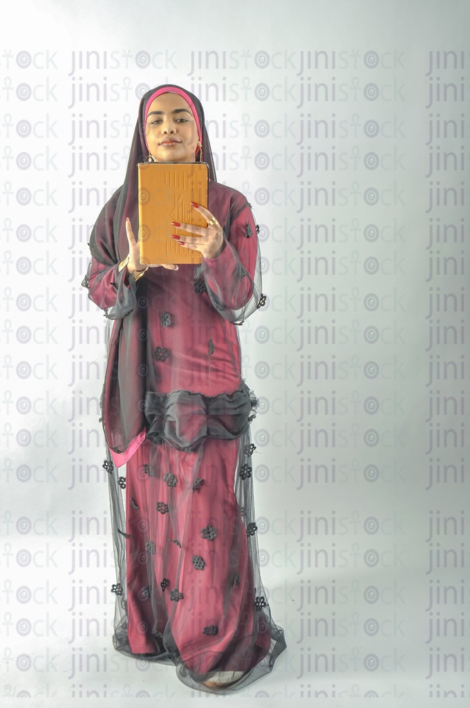 A Nubian Egyptian girl wearing Nubian clothes holding a tablet computer in her hand