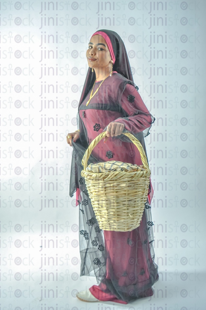 A farmer girl or a Nubian Egyptian girl wearing Nubian clothes holding a basket in her hand for putting vegetables or fruits