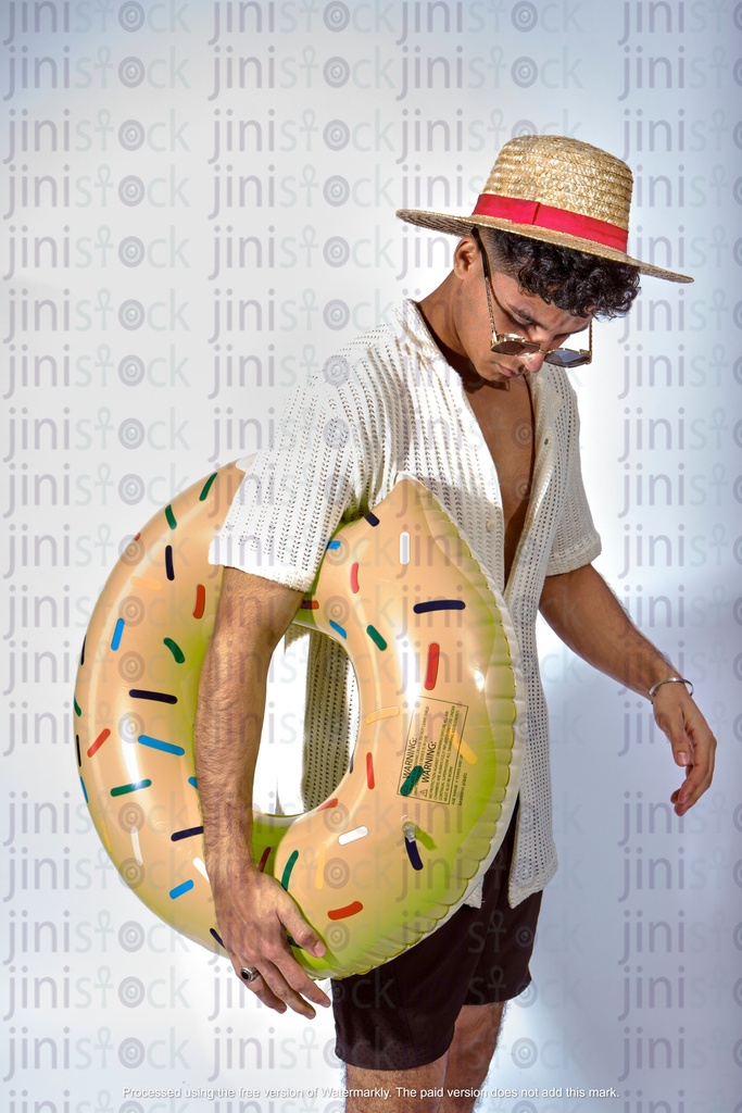 Egyptian man walking on beach holding water floater