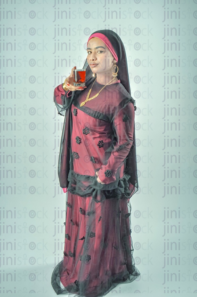 مزارعة مصرية أو امرأة مصرية نوبية ترتدي ثوبًا نوبيًا، وتضع حجابًا على رأسها، وتشرب كوبًا من الشاي