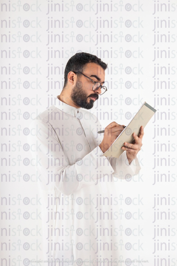 a stock image of a khaliji saudi gulf business man writing on papers