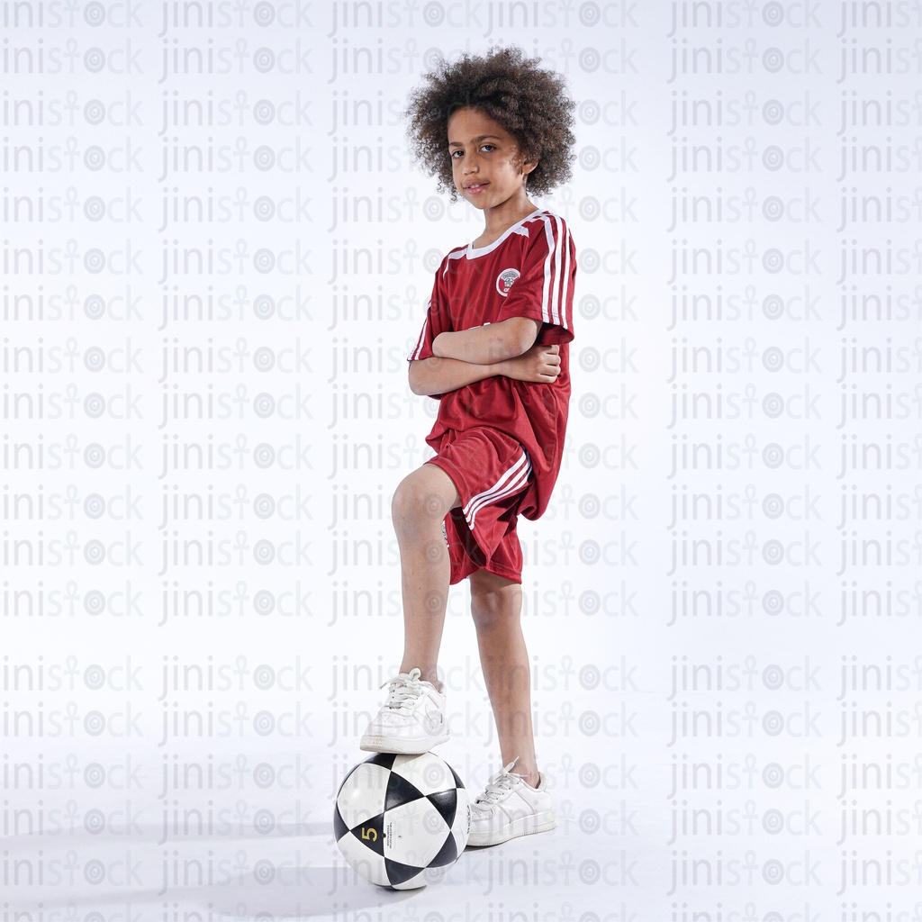 Young Qatar boy kid wearing Qatar national football team shirt EL ENABI