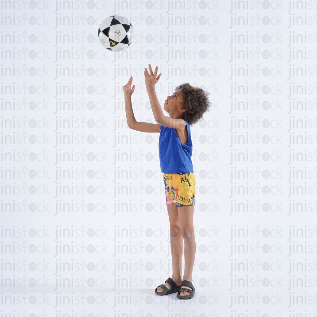 Egyptian boy with curly hair playing with football