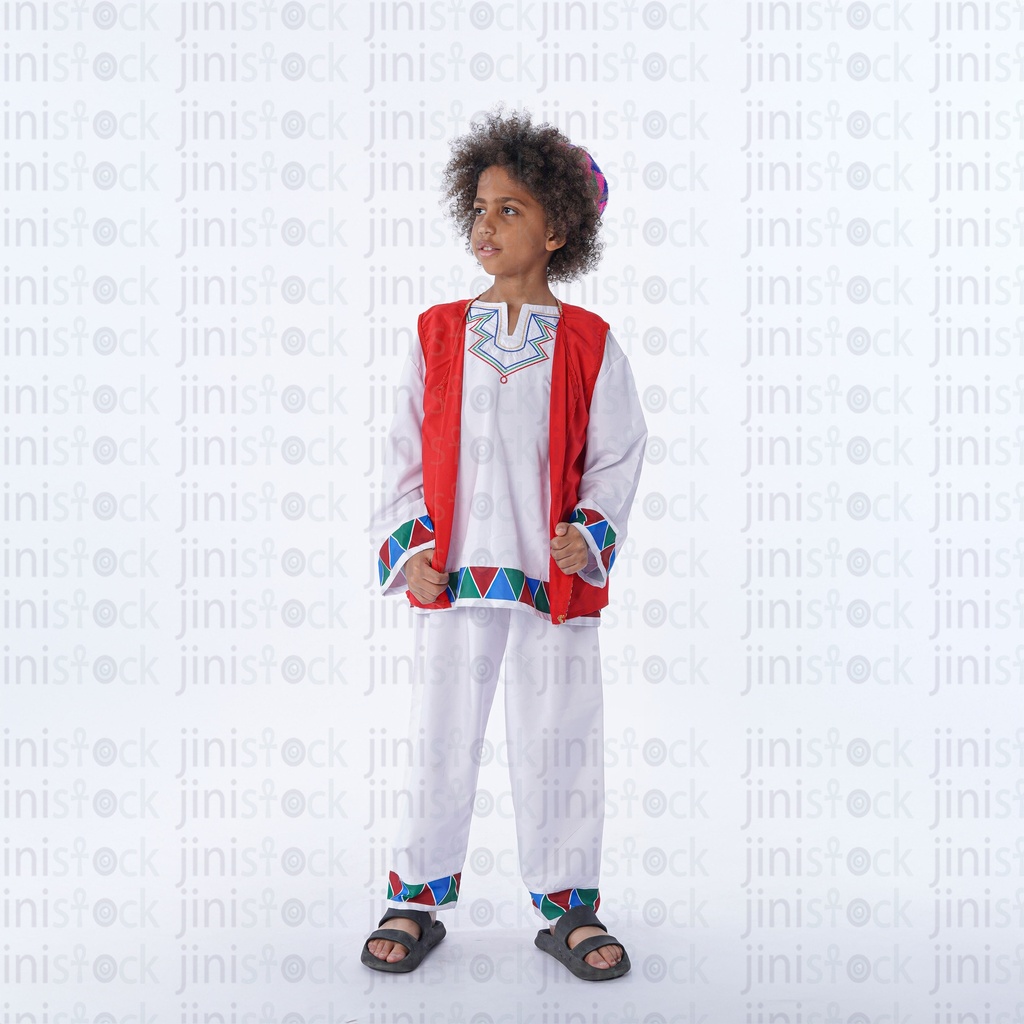 Nubian boy with curly hair standing looking to the side