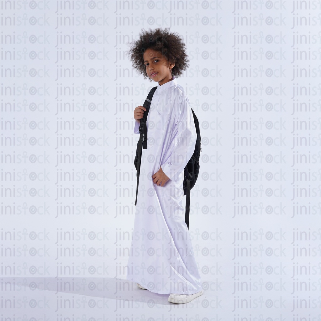 Khaliji saudi boy with curly hair from gulf carrying his school bag