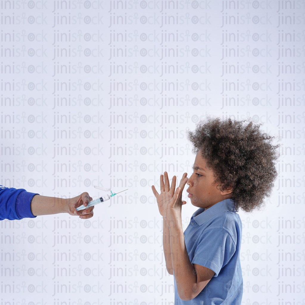boy with curly hair afraid from the needle