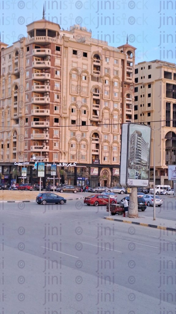A street in Maadi in Cairo with an area empty of cars or any means of transportation and tall buildings as a background for the designs.