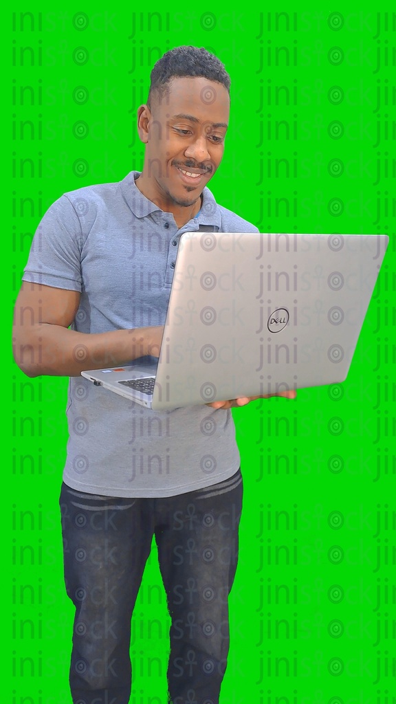 An Egyptian or Sudanese man working and holding a laptop computer in his hand