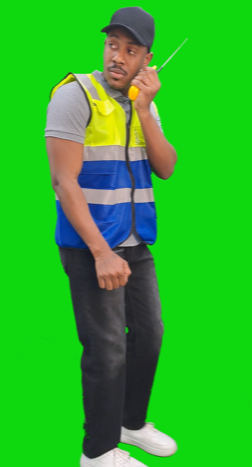 A security man wearing his work uniform and talking on a walkie-talkie or a wireless telephone.