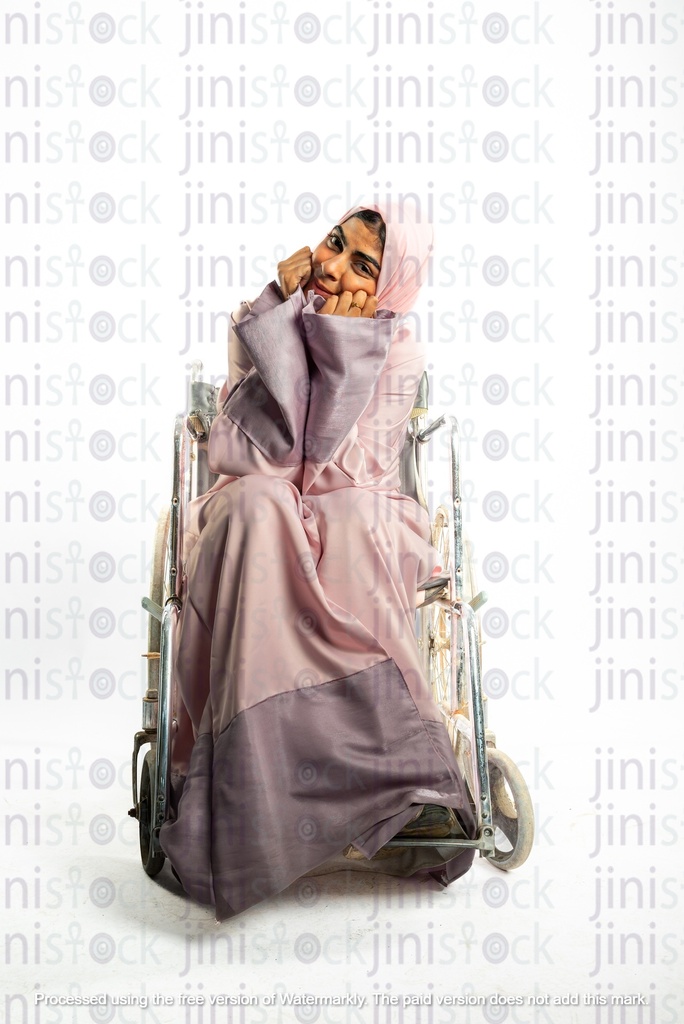 امرأة خليجية سعودية من الخليج على كرسي متحرك معاقة وتبتسم للكاميرا