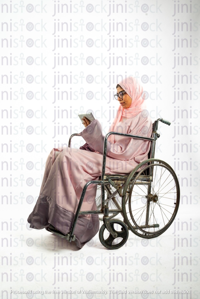 saudi khaliji woman from gulf on a wheelchair and working checking something in a folder or a file