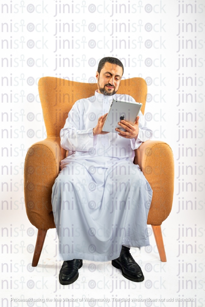 saudi khaliji man from gulf sitting on chair looking at ipad
