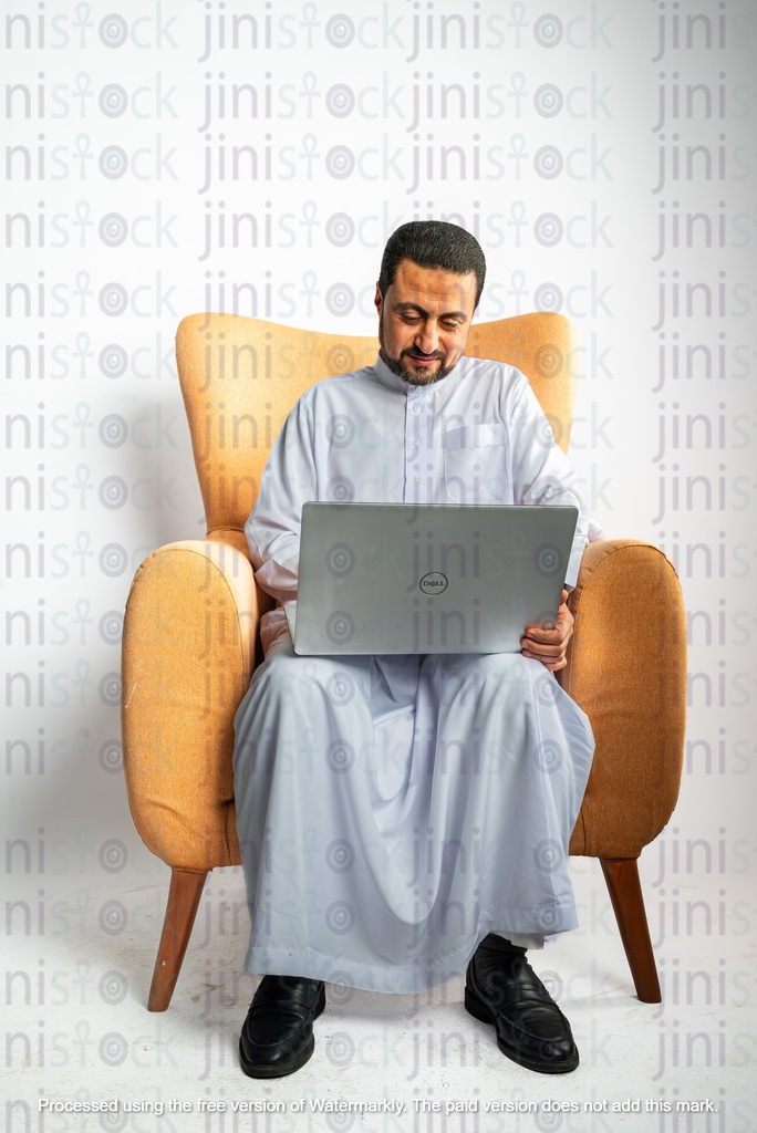 saudi khaliji man sitting on the chair working on his laptop from home