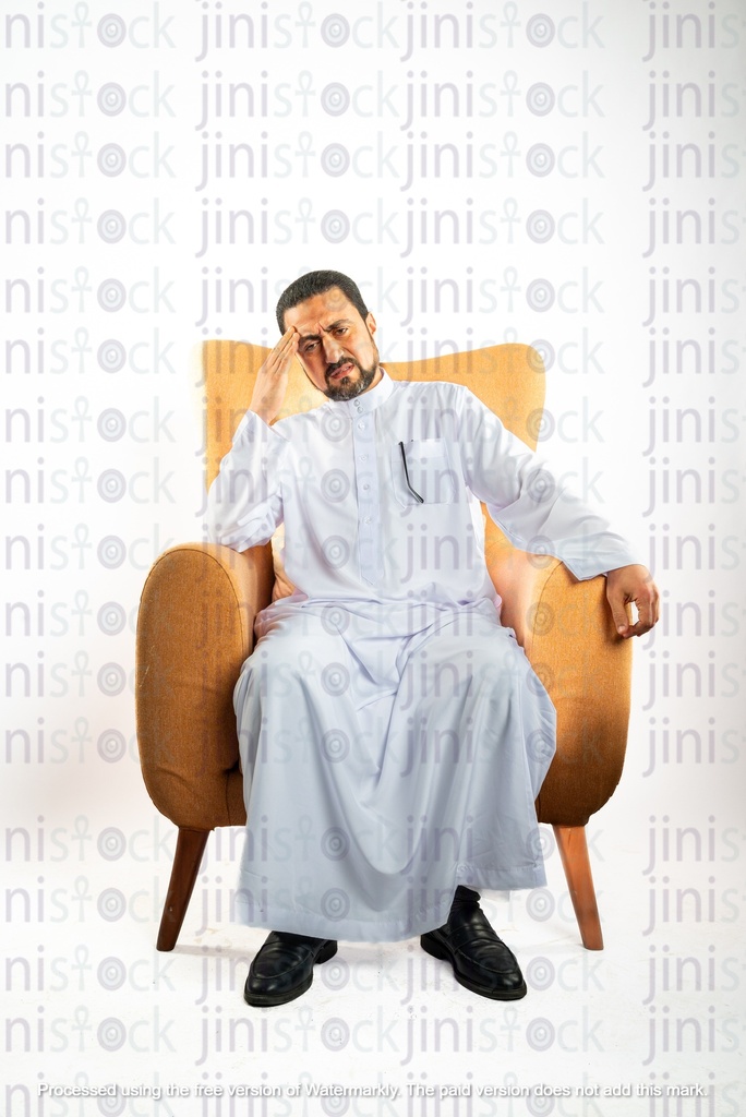 saudi khaliji man sitting on a chair and having a headache