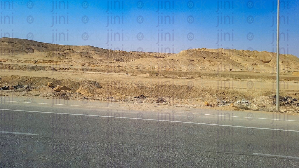 mountains and an empty Road with no cars or buses or any transportations on a traveling road in Egypt