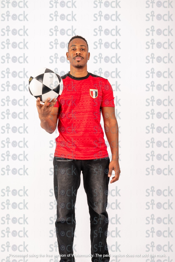 A Nubian young man wearing a sports T-shirt and holding a football