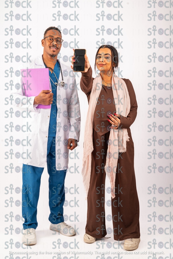 The mother and the doctor are taking a picture and the mother is holding the phone