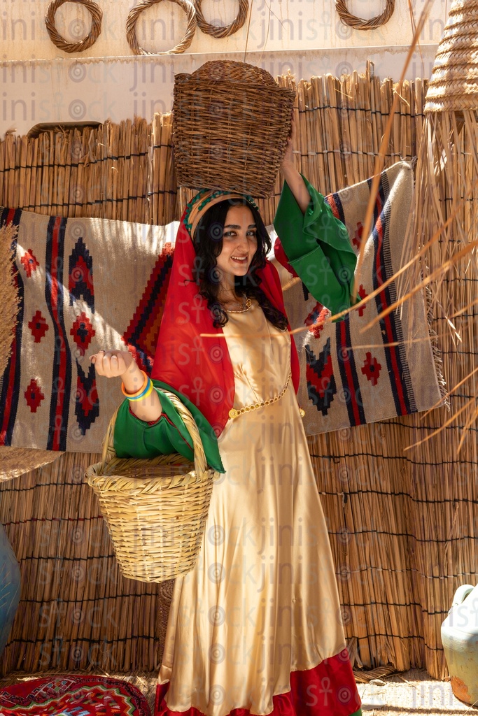 Beautiful Egyptian peasant woman carrying wicker cages