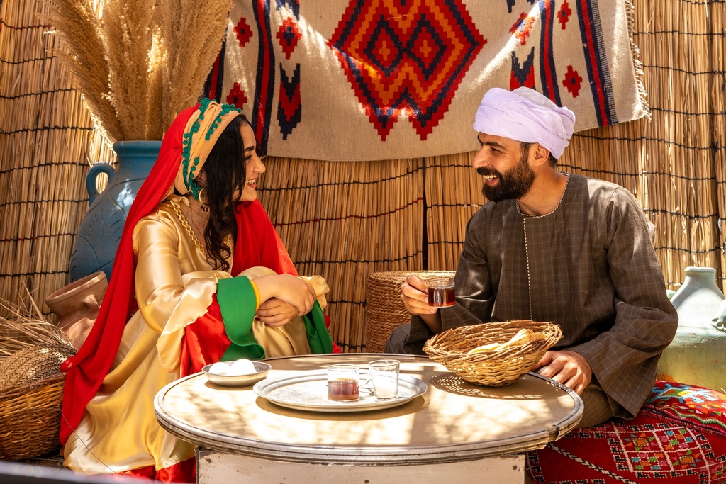 رجل مصري يجلس على الطبلية مع فتاة بزي فلاحي جميل