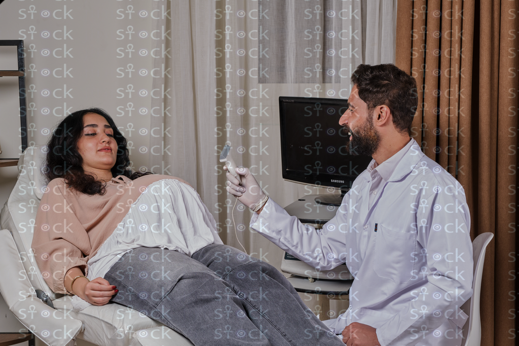 الطبيب يستعد لفحص بطن المريضة