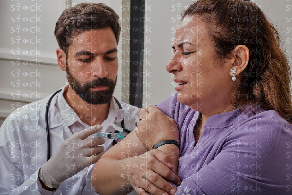 Doctor injecting patient’s arm 
