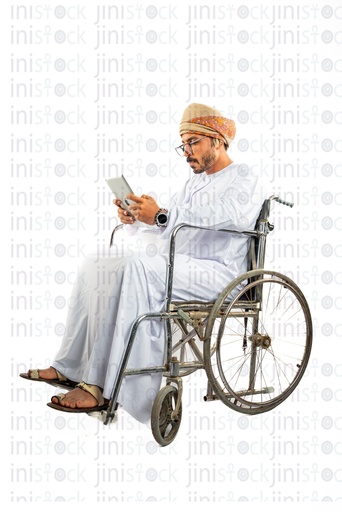رجل خليجي عماني عربي من الخليج على كرسي متحرك يكتب رسائل نصية على الهاتف