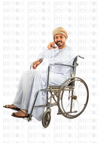 رجل خليجي عماني عربي من الخليج على كرسي متحرك يتحدث على الهاتف المحمول