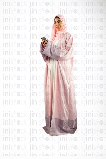 khaliji arab saudi woman from gulf looking at the camera and holding her mobile in her hands