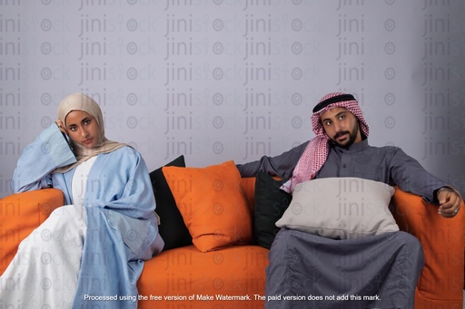 husband and a wife from khaliji saudi arabia from gulf sitting on a couch after a marriage fight