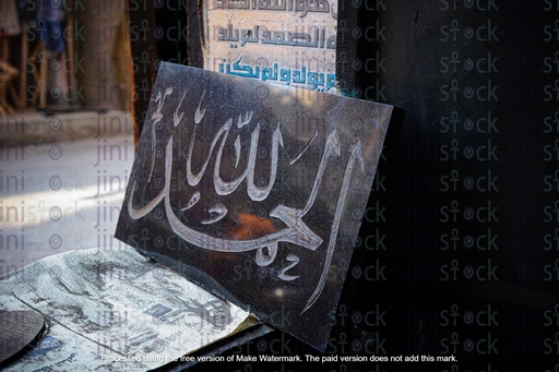 painting al hamdullah on a black board