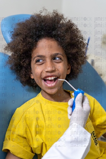 Young boy with curly hair at the dentist sitting on the dental chair