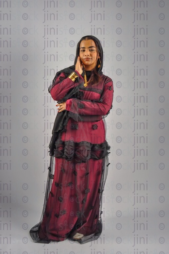 A Nubian woman from Egypt wearing Nubian clothes and putting her hand on her cheek