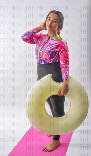 A girl wearing a burkini swimsuit and holding a float in her hand