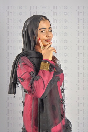 A Nubian woman from Egypt wearing Nubian clothes and putting her hand on her cheek