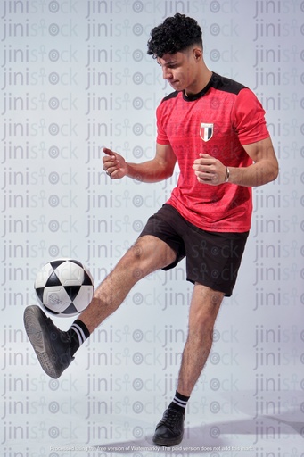 رجل مصري يرتدي قميص كرة القدم للمنتخب الوطني المصري ويلعب بالكرة