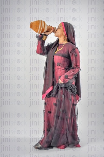 Nubian Egyptian woman wearing Nubian clothes and an Egyptian farmer girl drinking water from Qola