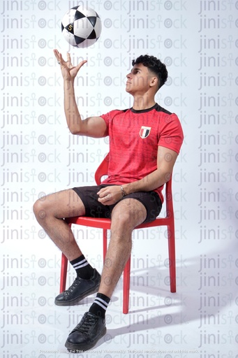 شاب مصري يرتدي قميص المنتخب الوطني المصري لكرة القدم ويدور الكرة