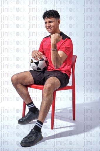 egyptian young man wearing the shirt of the Egyptian national team and holding a football